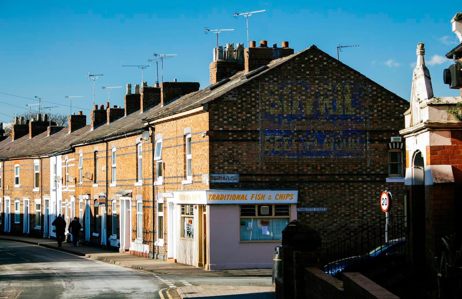 A brick terraced street corner with a traditional fish and chip shop